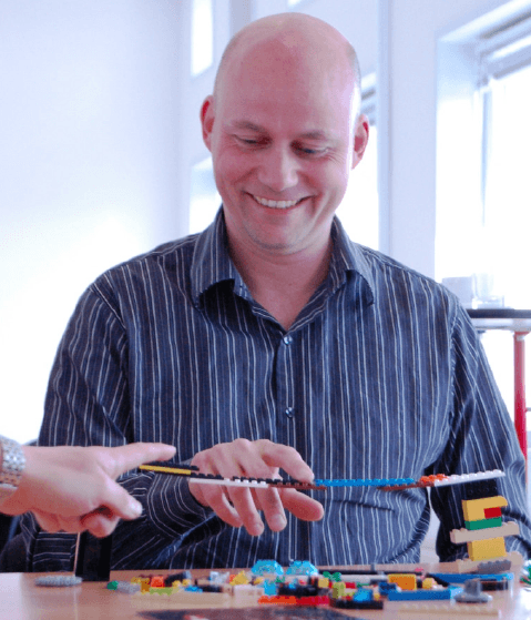 LEGO Serious Play — facilitator demonstrating a small model on stage